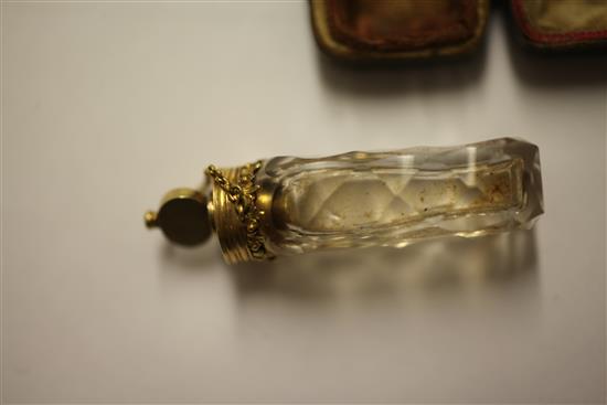 A cased late 18th century gold mounted cut glass miniature scent bottle with stopper and safety chain, approx. 2in.